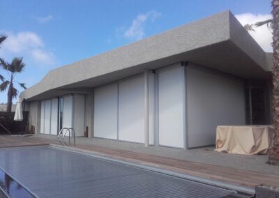 Toldos verticales instalados en grandes ventanales exteriores de una fachada en Tenerife